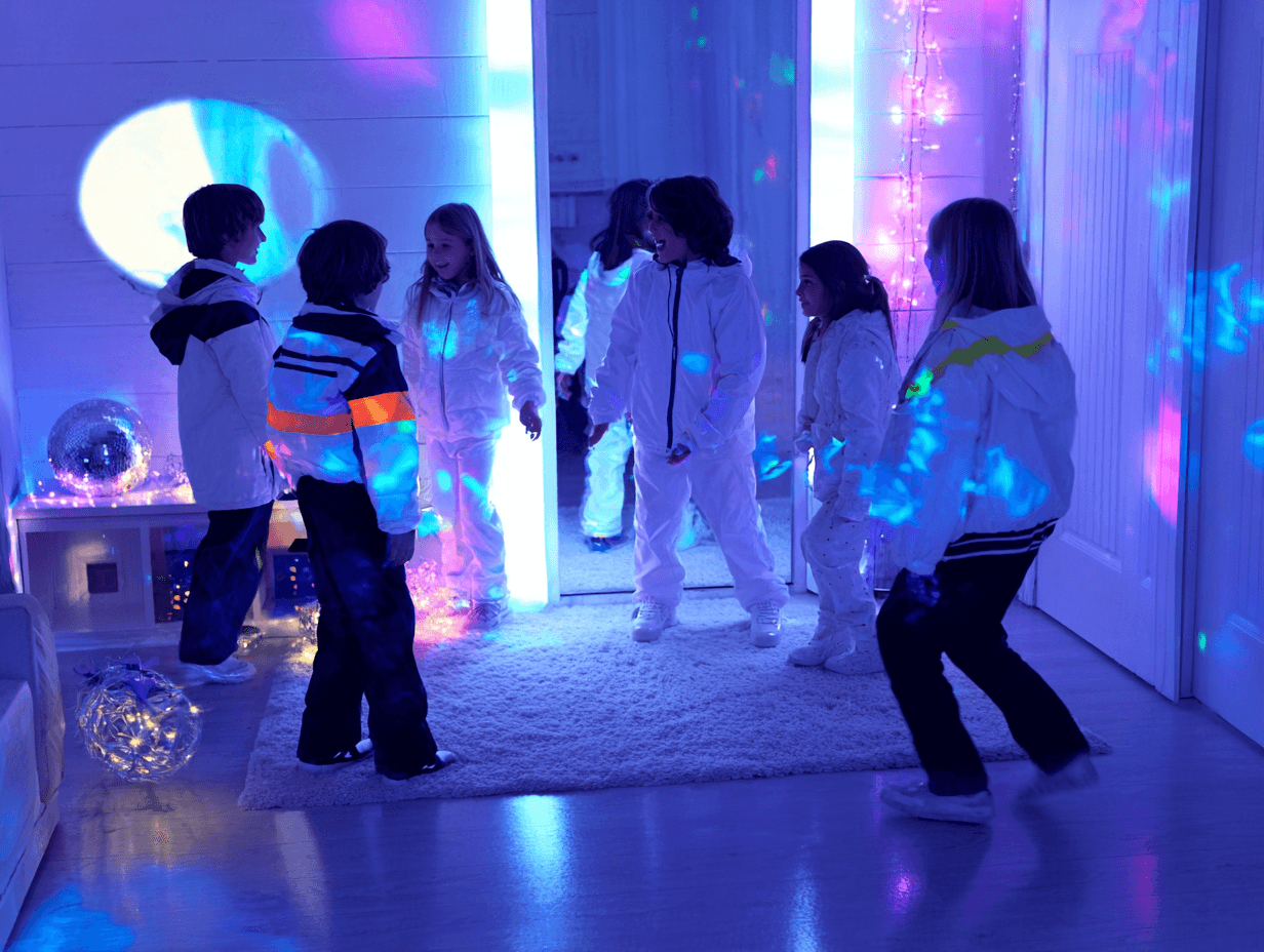 Kinder tanzen bei einer Lichterparty im Schwarzlicht